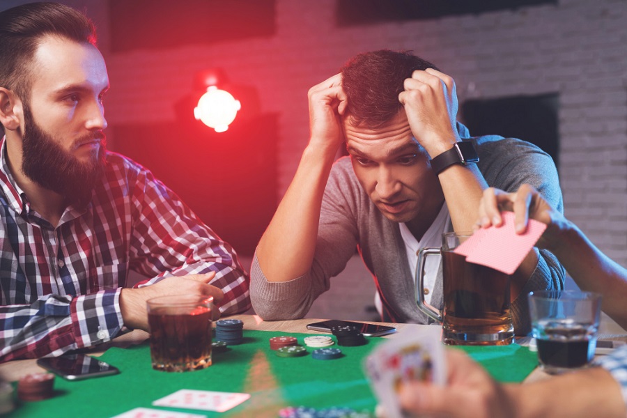 Man frustrated at losing a game of cards at a game night